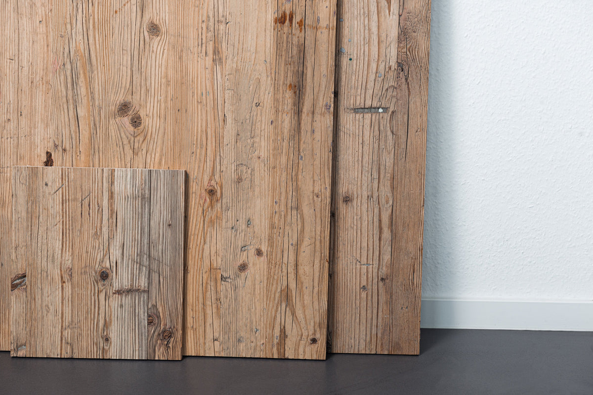 Dreischichtplatten BASE aus Altholz an eine Wand gelehnt