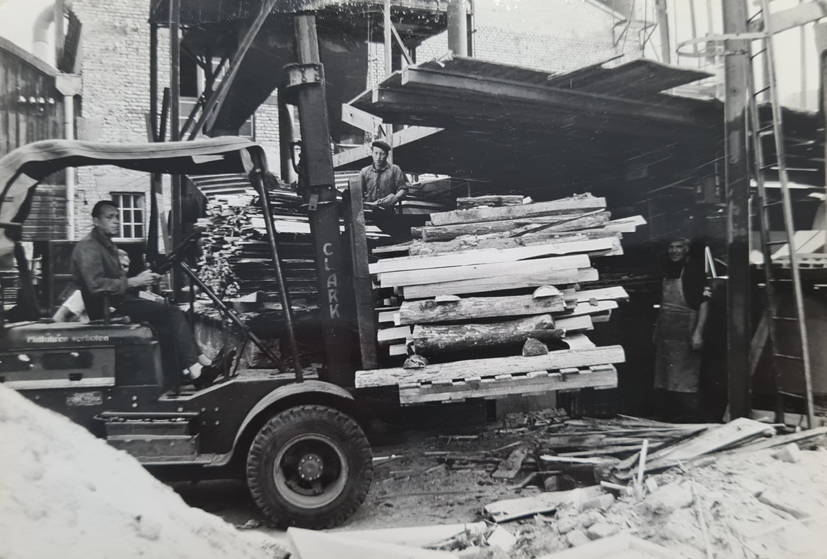 Historische Aufnahme: Gabelstapler transportiert Gerüstbohlen bei Schollmayer Holz