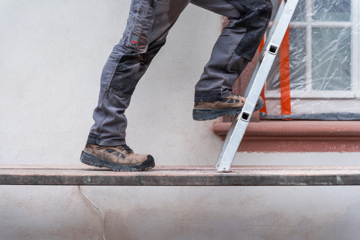 Gerüstbauer auf Gerüstbohlen im Einsatz auf der Baustelle