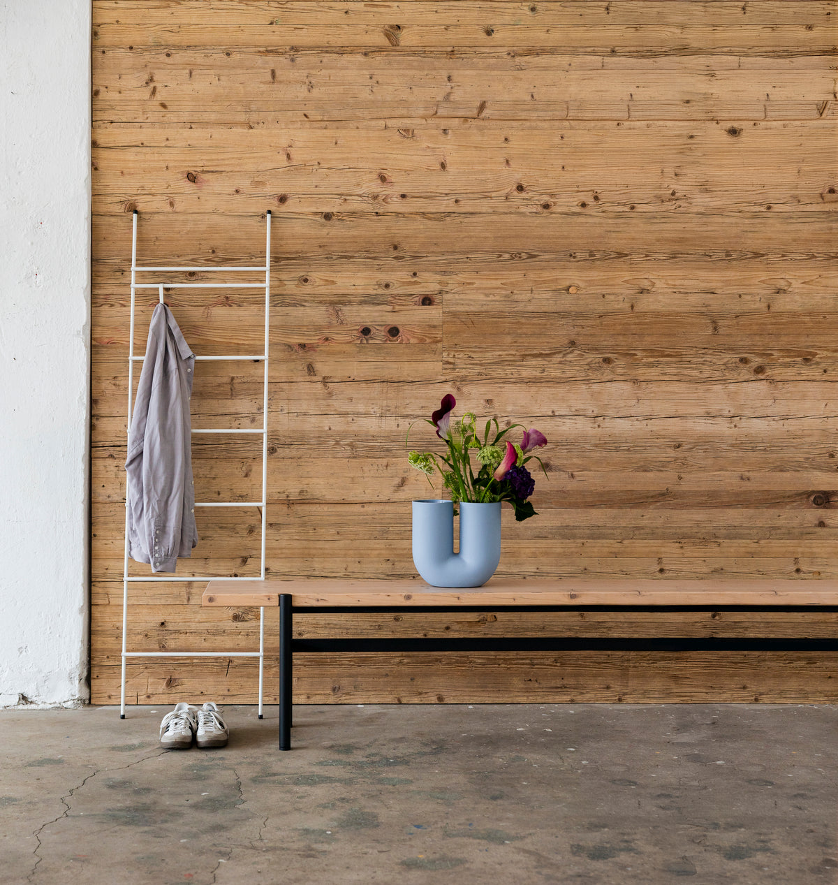 Wandverkleidung FACE aus Gerüstbohlen mit Bank und Blumen
